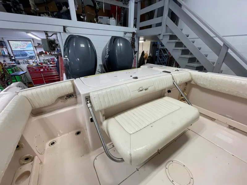 Slide: The Image of 2010 Grady-White 257 Advance boat interior with seating and dual engines in a workshop. - 22
