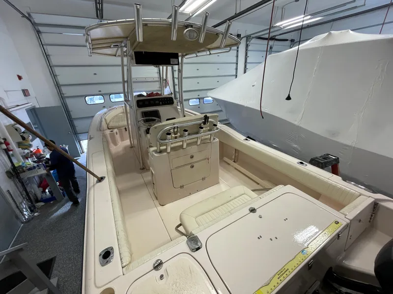 Slide: The Image of 2010 Grady-White 257 Advance boat in a garage, showcasing interior and helm. - 28