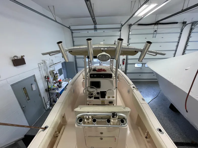 Slide: The Image of 2010 Grady-White 257 Advance boat in a garage, showcasing helm and rod holders. - 30