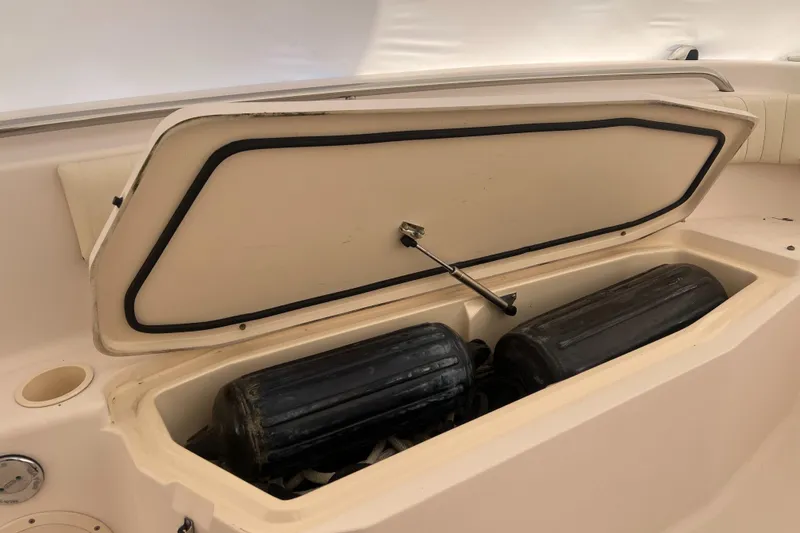 Slide: The Image of 2010 Grady-White 257 Advance boat storage compartment with black fenders inside. - 32
