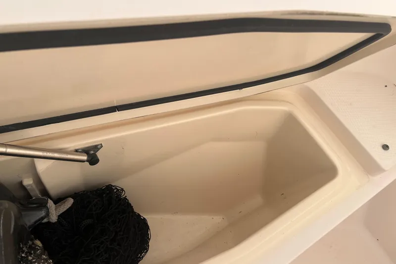 Slide: The Image of Open storage compartment on 2010 Grady-White 257 Advance boat with netting inside. - 33