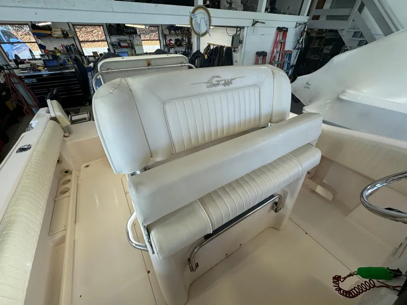 Slide: The Image of 2010 Grady-White 257 Advance boat interior with white seating in a garage setting. - 39
