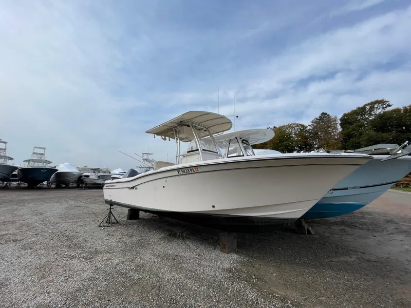 Slide: The Image of 2010 Grady-White 257 Advance boat on gravel lot, surrounded by other boats. - 5