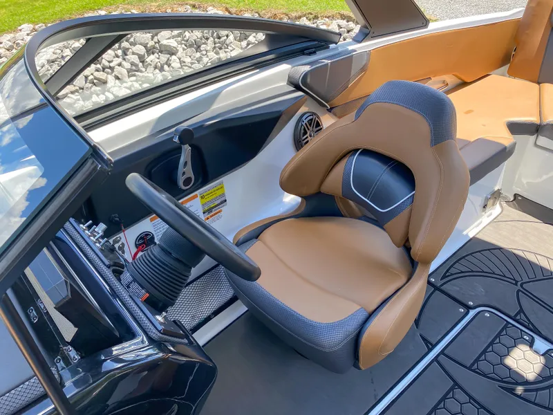 Slide: The Image of 2022 Scarab 215 ID Wake boat interior with tan and black captain's seat. - 10