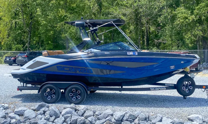 Slide: The Image of 2022 Scarab 215 ID Wake boat on a trailer, parked outdoors. - 20