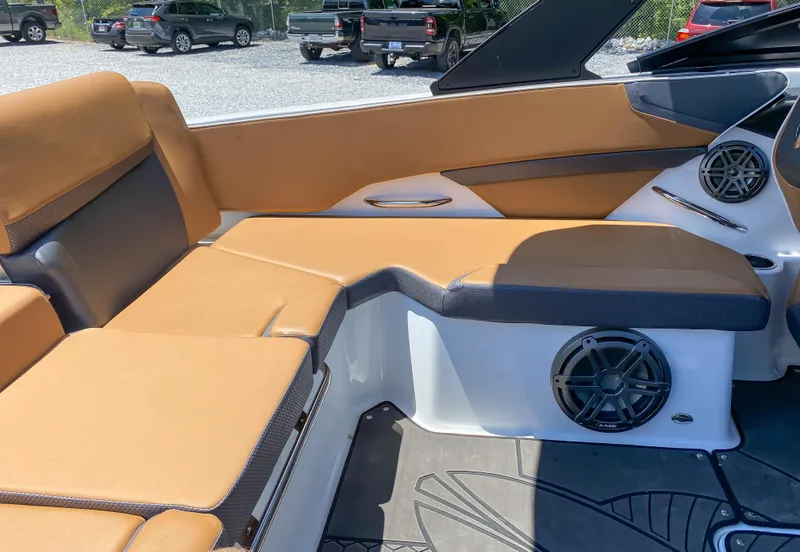 Slide: The Image of 2022 Scarab 215 ID Wake boat interior with tan seating and speaker system. - 7