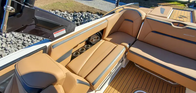 Slide: The Image of 2022 MasterCraft XStar boat interior with tan leather seats and cup holders. - 10