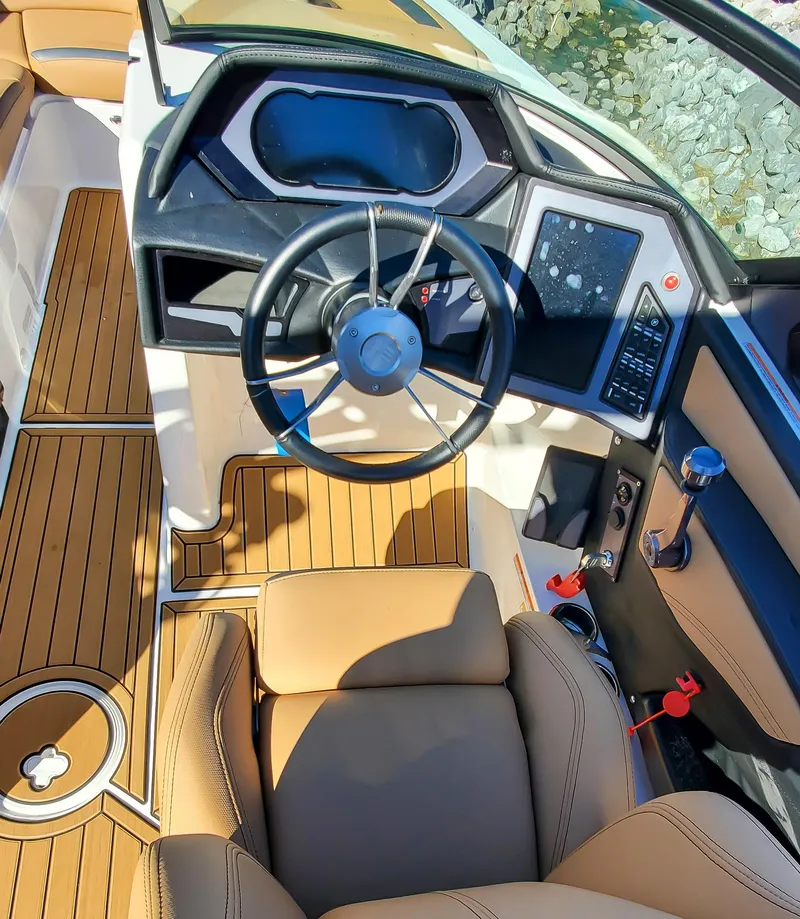Slide: The Image of 2022 MasterCraft XStar boat interior with modern dashboard and luxurious seating. - 11