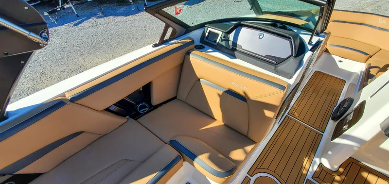 Slide: The Image of 2022 MasterCraft XStar boat interior with tan and black seating and modern dashboard. - 13