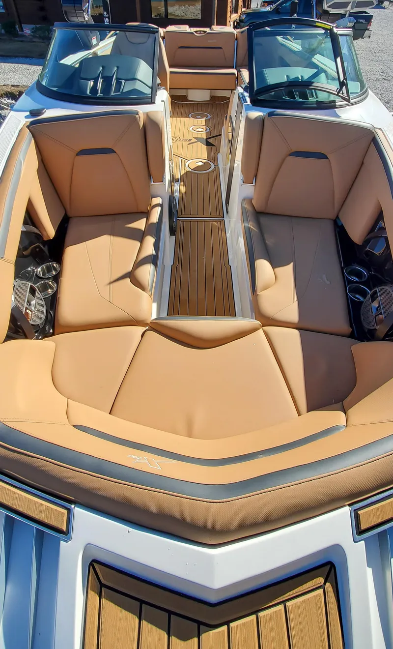Slide: The Image of 2022 MasterCraft XStar boat interior with tan leather seats and wood accents. - 14