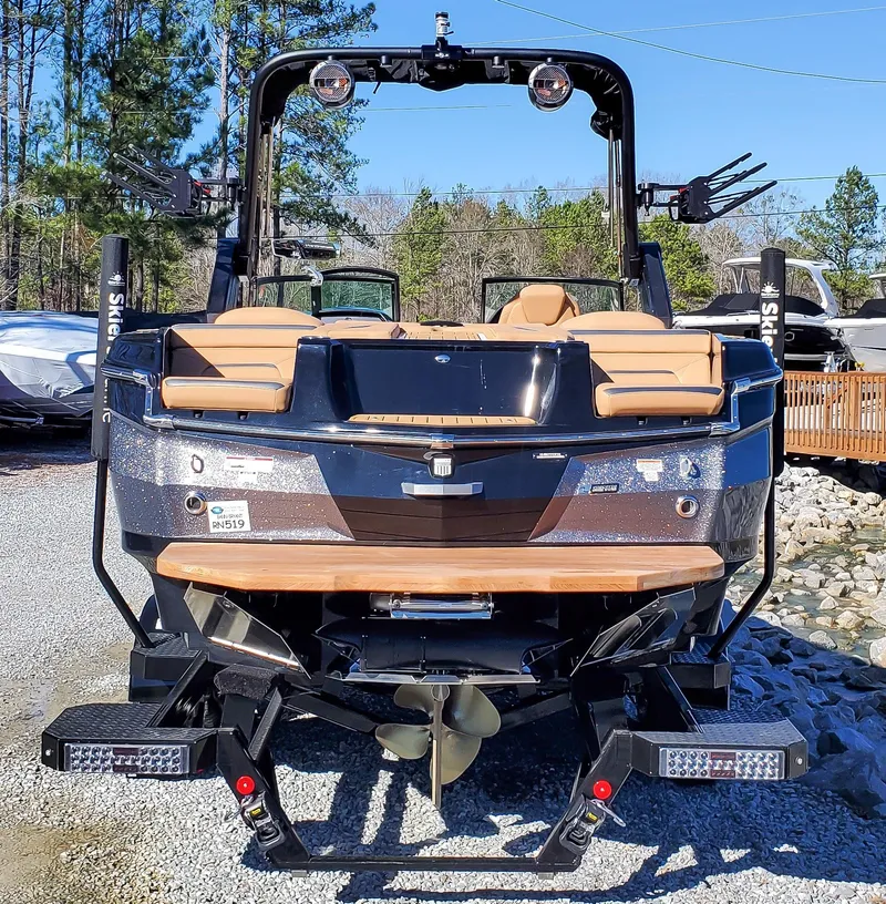 Slide: The Image of 2022 MasterCraft XStar boat rear view with wakeboard tower and propeller. - 2