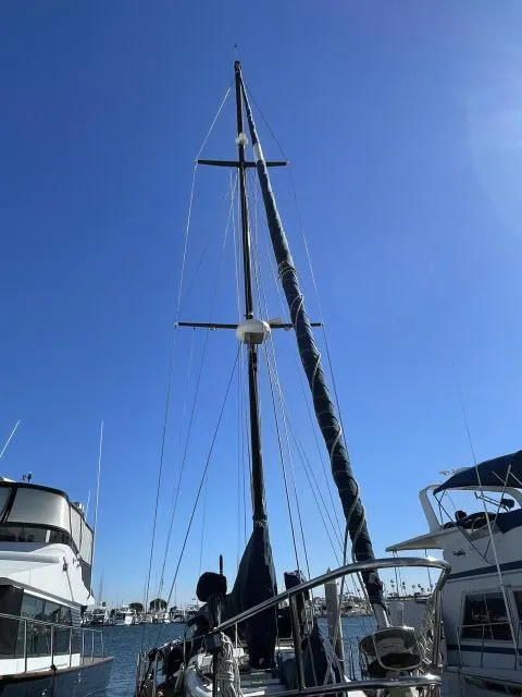 Slide: The Image of 1982 Formosa 42 sailboat docked at a marina under a clear blue sky. - 15