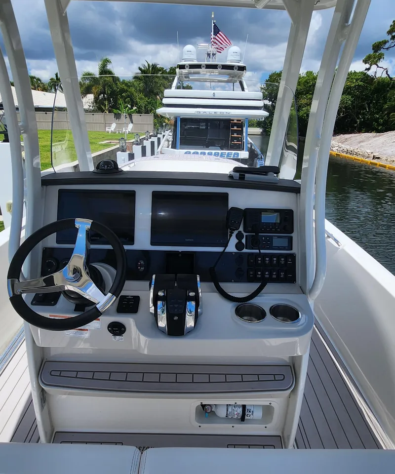 Slide: The Image of 2021 Boston Whaler Dauntless 27 boat helm with modern controls and navigation screens. - 13