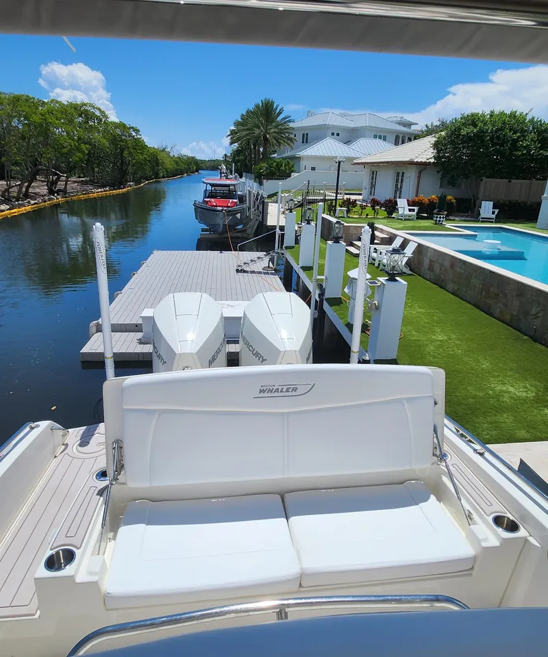 Slide: The Image of Boston Whaler Dauntless 27 (2021) docked by a luxurious waterfront property. - 17