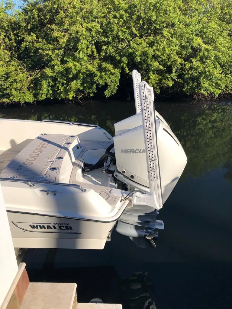Slide: The Image of 2021 Boston Whaler Dauntless 27 boat with Mercury engine docked by lush greenery. - 19