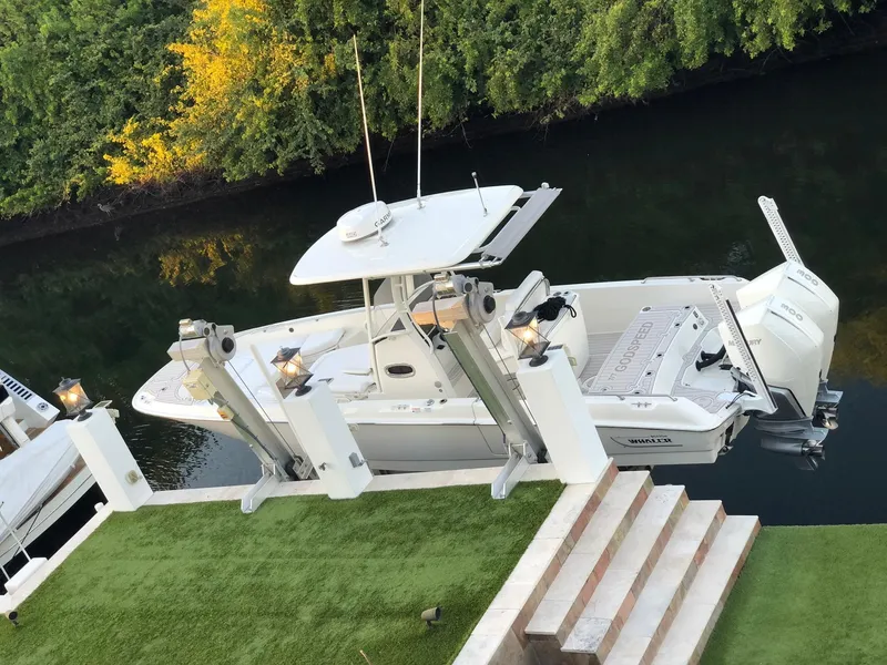 Slide: The Image of 2021 Boston Whaler Dauntless 27 docked by lush greenery. - 2