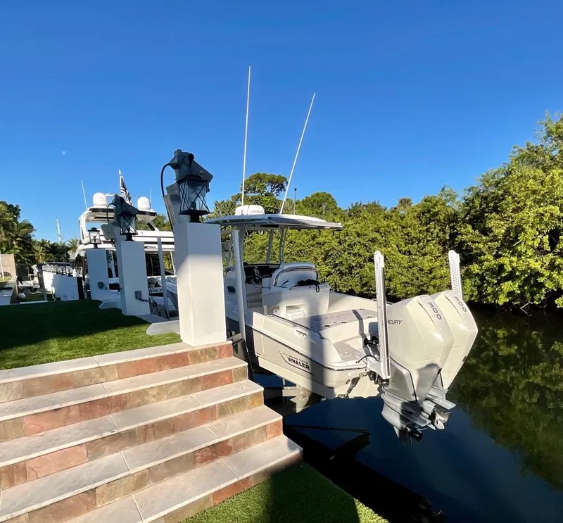 Slide: The Image of 2021 Boston Whaler Dauntless 27 docked by a lush riverside. - 20
