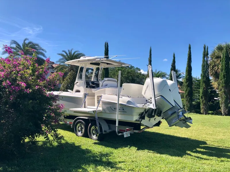 Slide: The Image of 2021 Boston Whaler Dauntless 27 boat on trailer in a lush garden. - 4