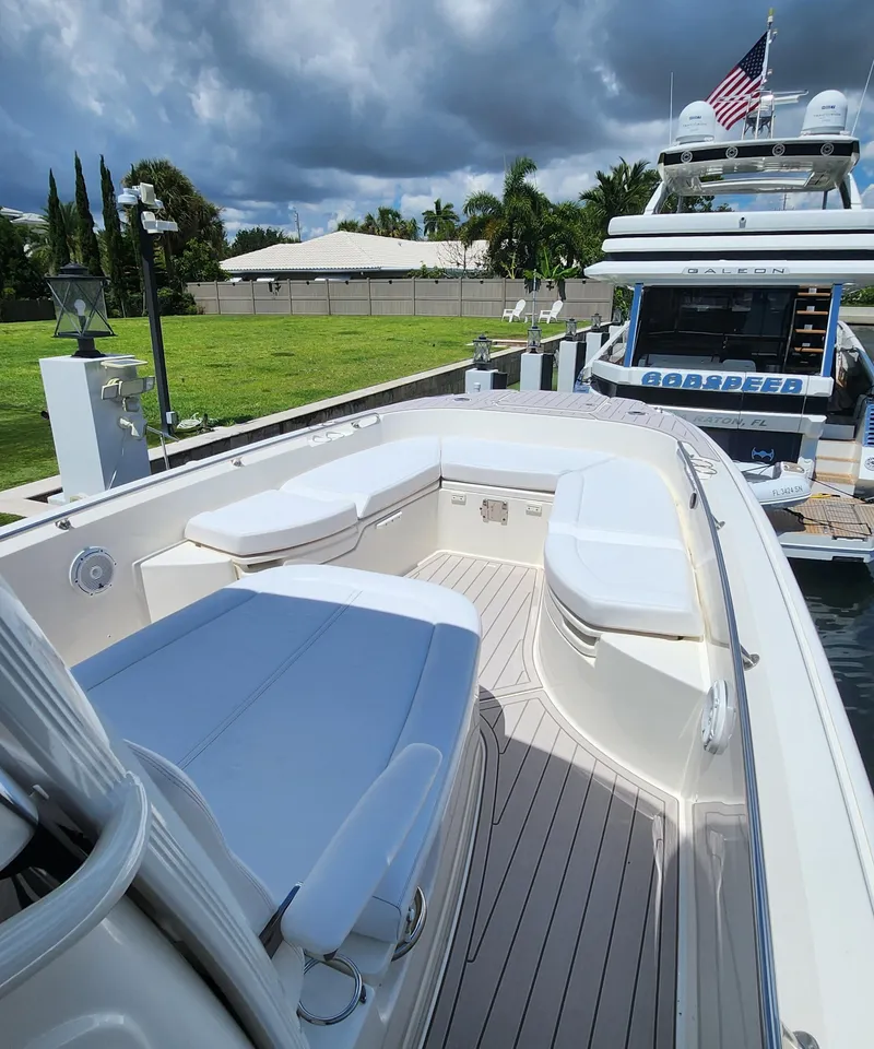 Slide: The Image of 2021 Boston Whaler Dauntless 27 boat docked, featuring spacious seating and modern design. - 7