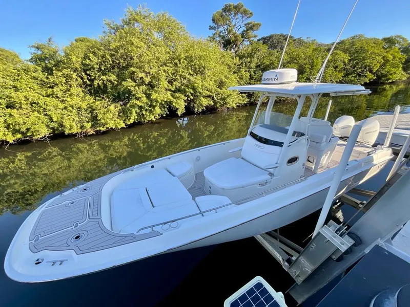 Slide: The Image of 2021 Boston Whaler Dauntless 27 boat docked near lush greenery. - 8