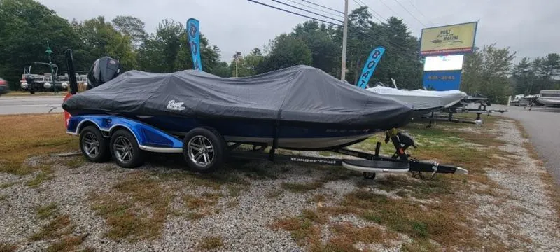 The Image of 2023 Ranger Z 521 RC boat covered on a trailer in a dealership lot. - 1