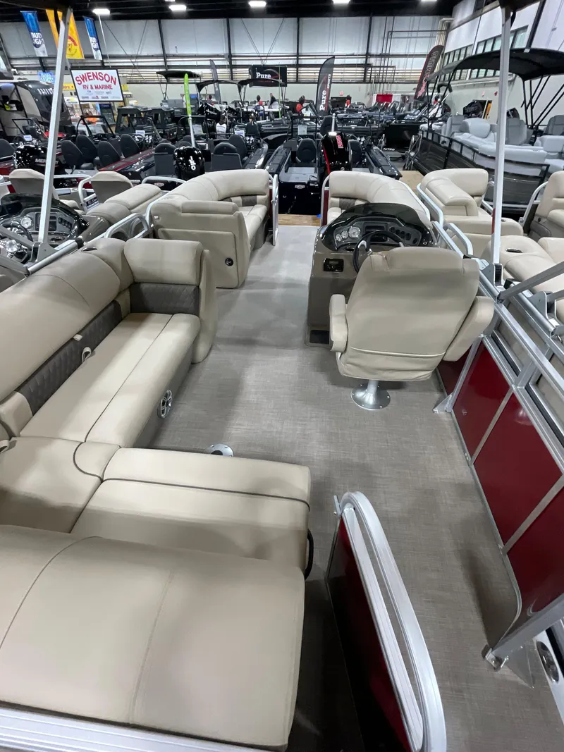 Slide: The Image of 2023 Sun Tracker Party Barge 20 DLX interior with beige seating in showroom. - 10