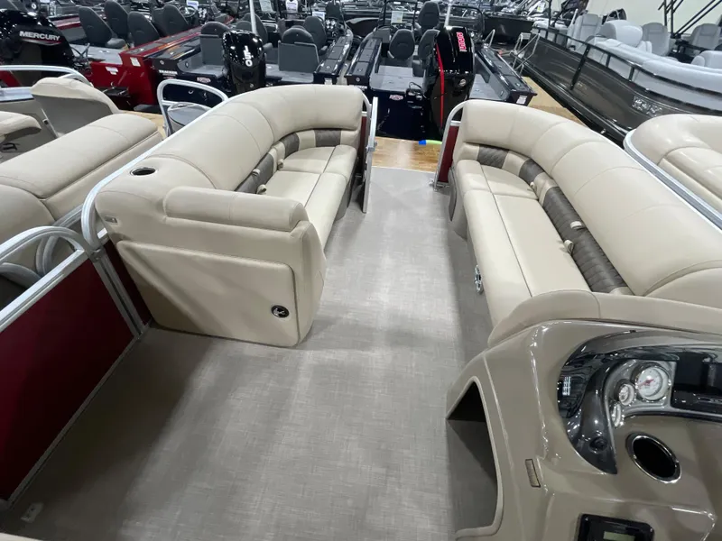 Slide: The Image of 2023 Sun Tracker Party Barge 20 DLX interior with beige seating and modern dashboard. - 12