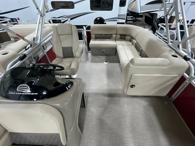 Slide: The Image of 2023 Sun Tracker Party Barge 20 DLX interior with beige seating and steering console. - 5