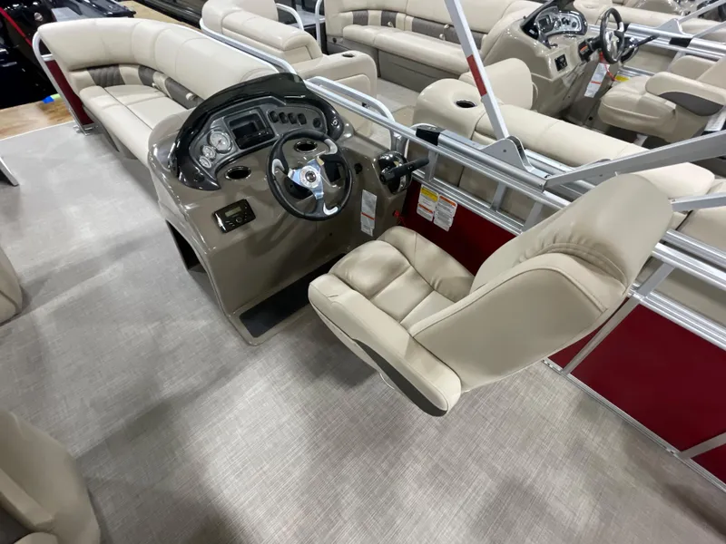 Slide: The Image of 2023 Sun Tracker Party Barge 20 DLX interior with beige seating and steering console. - 7