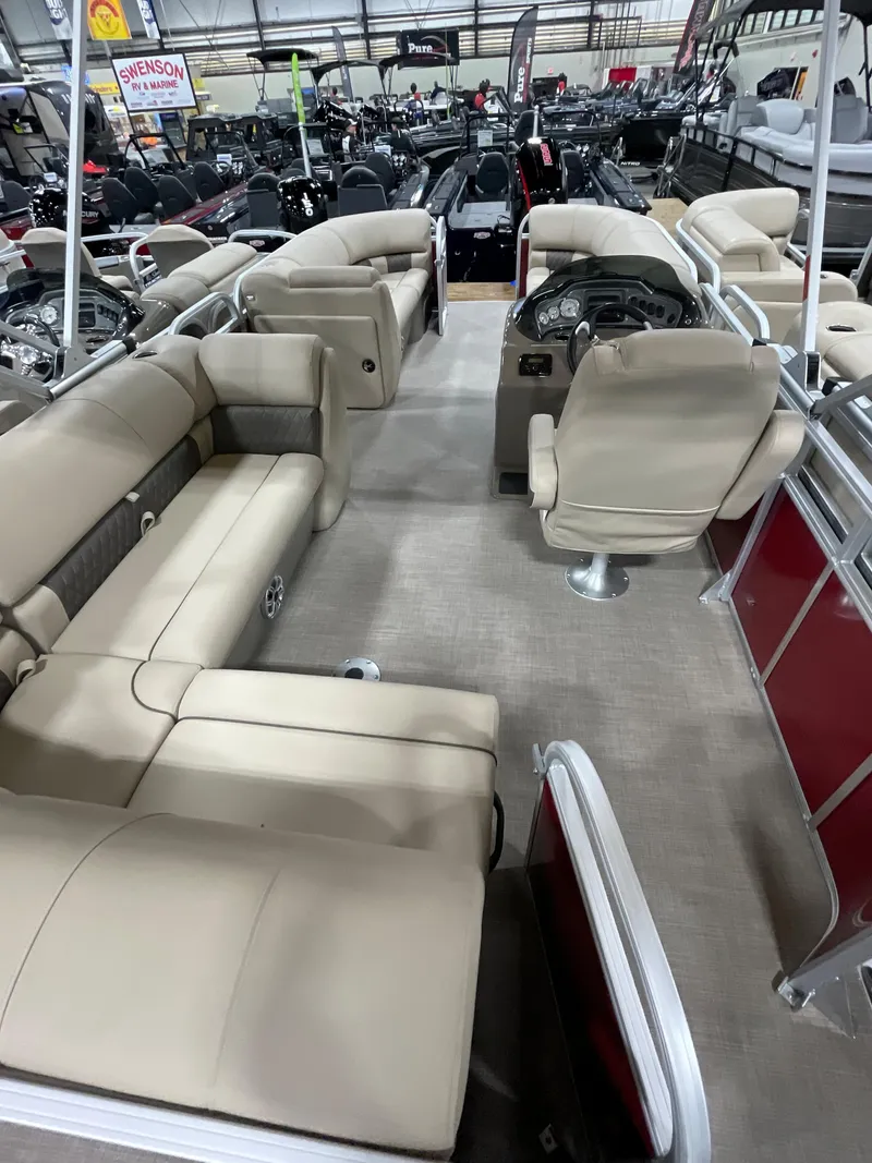Slide: The Image of 2023 Sun Tracker Party Barge 20 DLX interior with beige seating and steering console. - 8