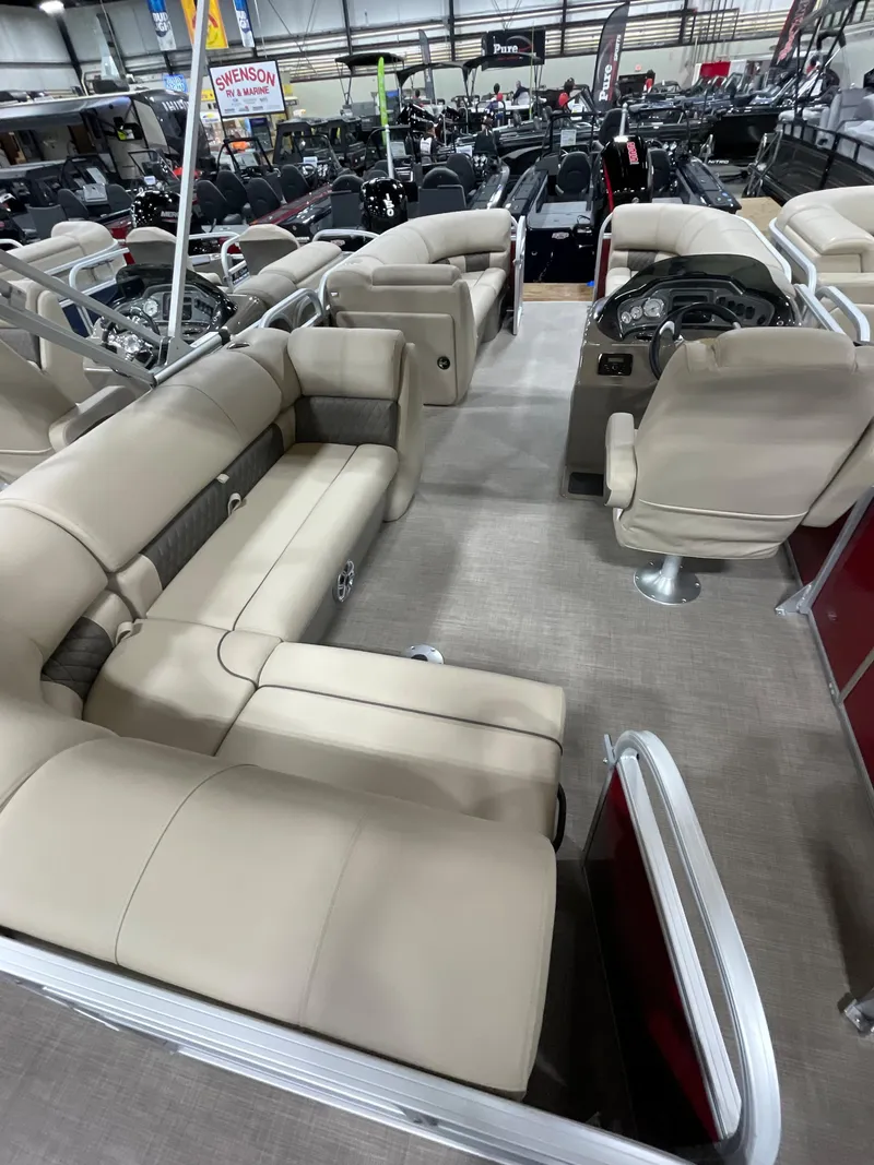 Slide: The Image of 2023 Sun Tracker Party Barge 20 DLX interior with beige seating and steering console. - 9