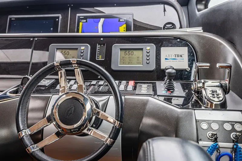 Slide: The Image of Control panel of a 2013 Sunseeker Predator 84 yacht with steering wheel and navigation displays. - 38