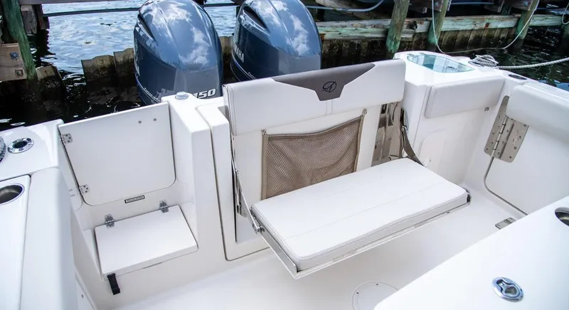 Slide: The Image of 2023 Sailfish 272 CC boat interior with foldable seating and twin Yamaha engines. - 2