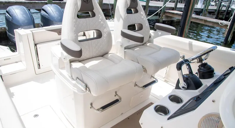 Slide: The Image of 2023 Sailfish 272 CC boat interior with dual captain's chairs and control console. - 3