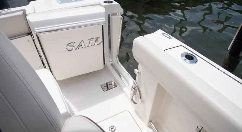 Slide: The Image of 2023 Sailfish 272 CC boat interior, featuring sleek white seating and a SAIL branded compartment. - 6