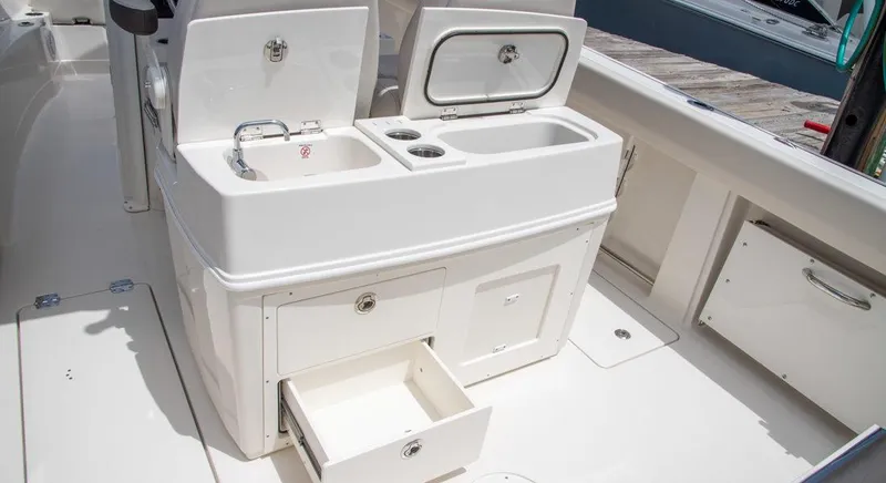 Slide: The Image of 2023 Sailfish 272 CC boat interior with sink, storage compartments, and drawers. - 7