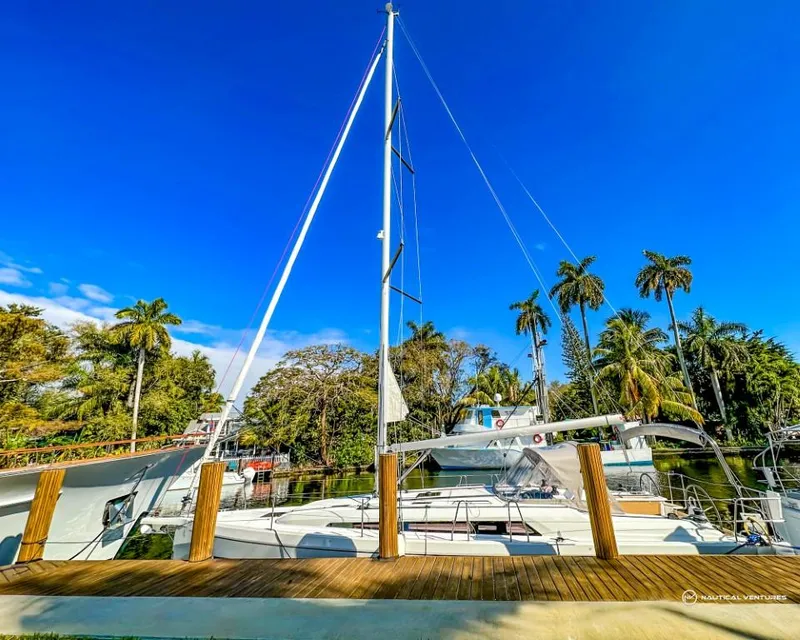Slide: The Image of 2024 Beneteau Oceanis 40.1 sailboat docked, surrounded by palm trees and clear blue sky. - 1