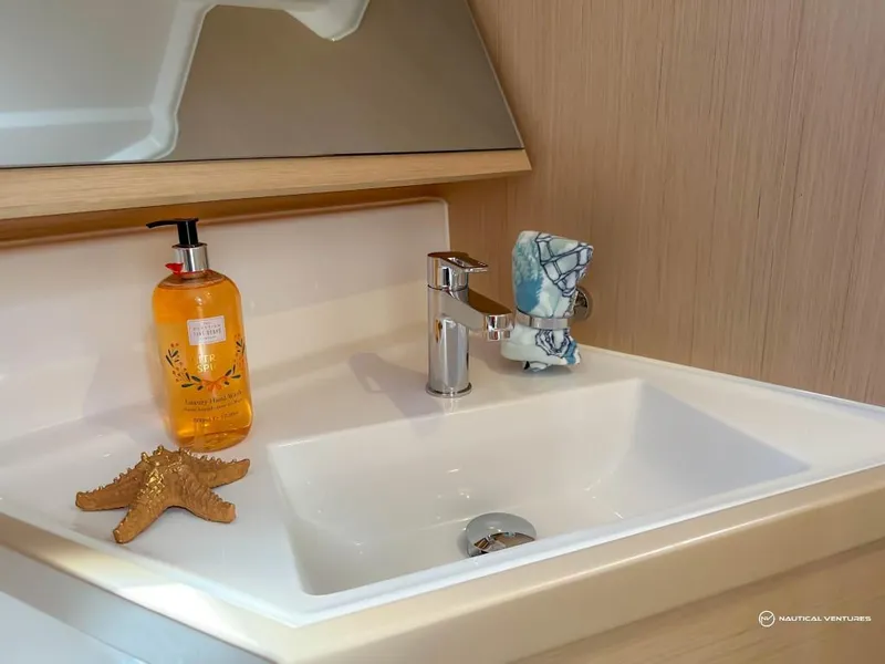 Slide: The Image of Modern bathroom sink in 2024 Beneteau Oceanis 40.1 yacht with soap dispenser and starfish. - 19