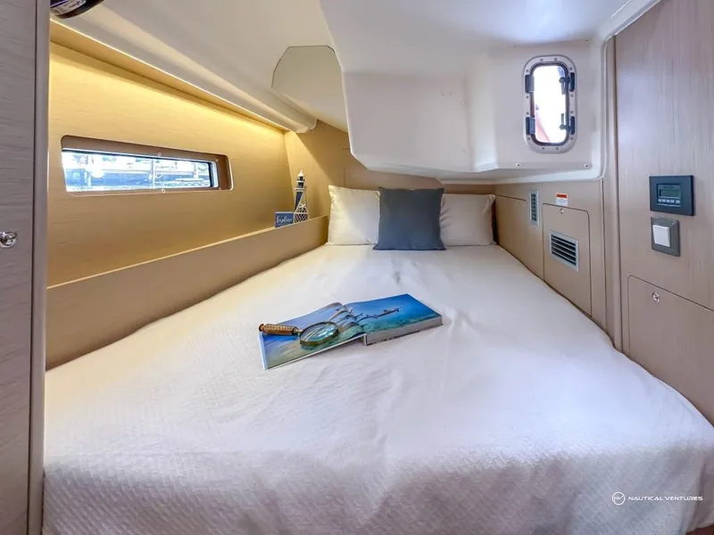 Slide: The Image of 2024 Beneteau Oceanis 40.1 cabin interior with bed and porthole window. - 21