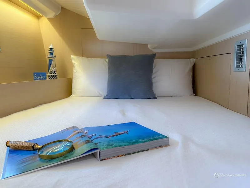 Slide: The Image of Cozy bedroom in 2024 Beneteau Oceanis 40.1 yacht with book and magnifying glass. - 23