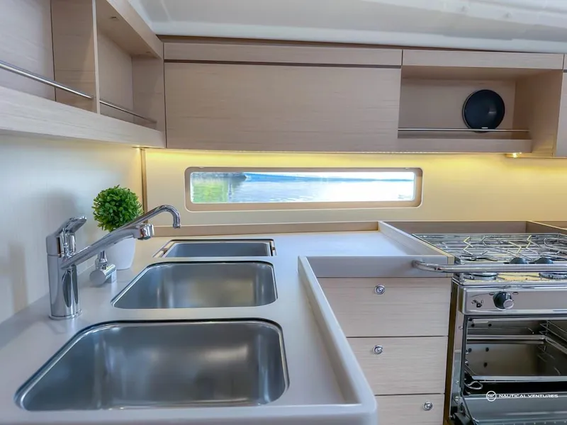Slide: The Image of Modern kitchen in 2024 Beneteau Oceanis 40.1 yacht with dual sinks and stainless steel appliances. - 33