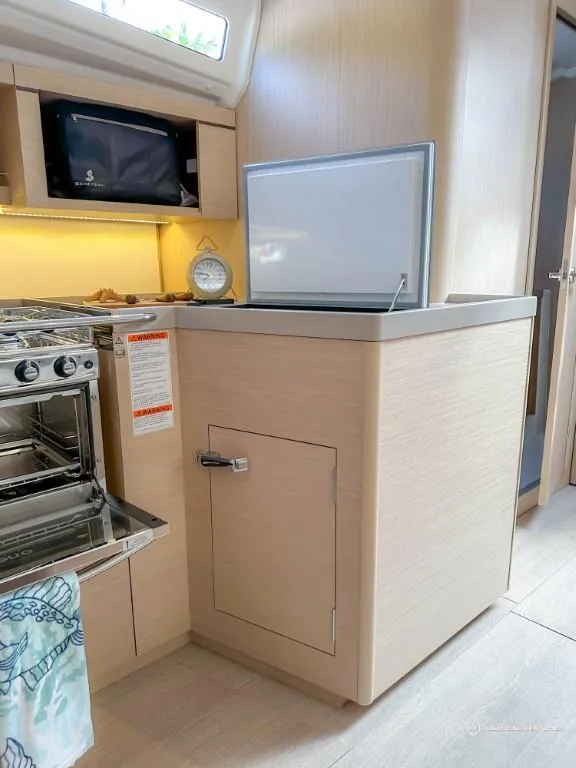Slide: The Image of 2024 Beneteau Oceanis 40.1 yacht kitchen with modern appliances and light wood cabinetry. - 36
