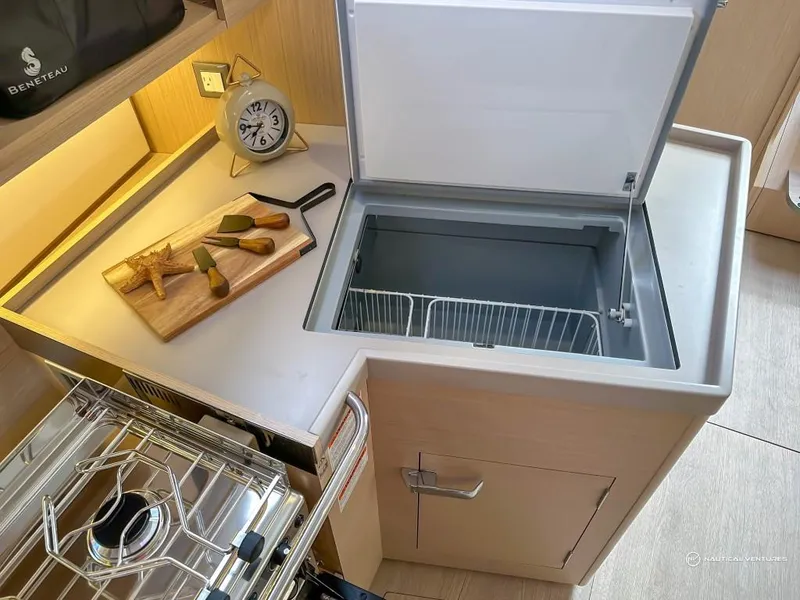 Slide: The Image of Beneteau Oceanis 40.1 2024 yacht kitchen with stove, cutting board, and open refrigerator. - 37