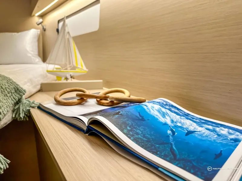 Slide: The Image of 2024 Beneteau Oceanis 40.1 cabin interior with nautical decor and open book. - 40