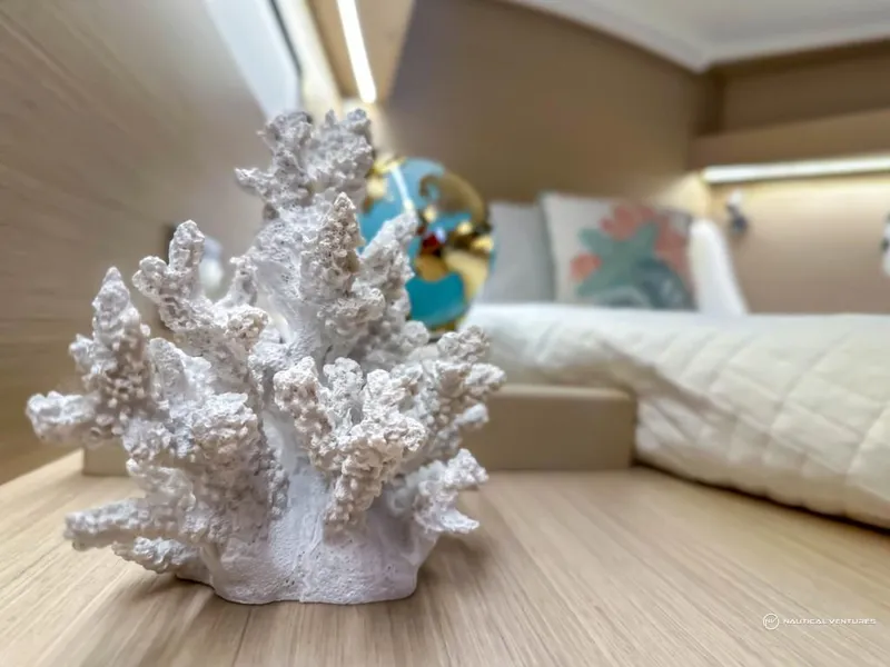 Slide: The Image of Beneteau Oceanis 40.1 2024 interior with decorative coral and cozy bedding. - 41