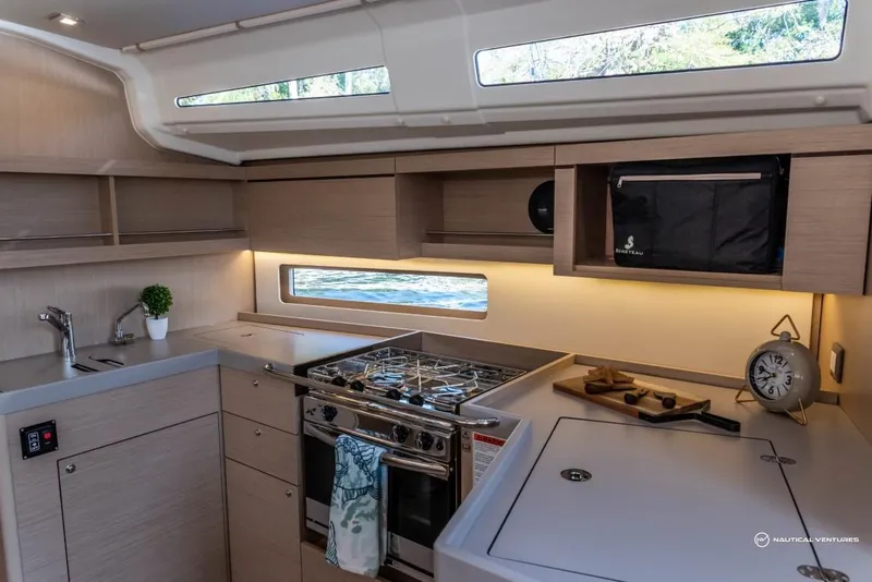 Slide: The Image of Modern kitchen in 2024 Beneteau Oceanis 40.1 sailboat with stove, sink, and ample storage. - 47