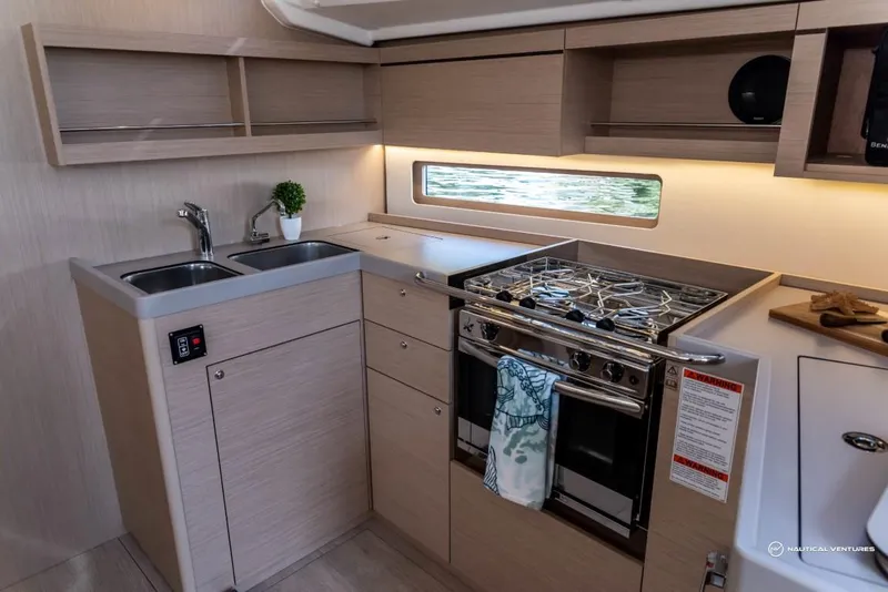 Slide: The Image of Modern kitchen in 2024 Beneteau Oceanis 40.1 yacht with stove, sink, and storage. - 49