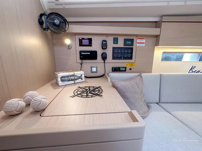 Slide: The Image of Interior of 2024 Beneteau Oceanis 40.1 yacht with navigation controls and cozy seating area. - 5