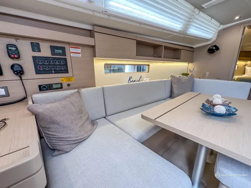 Slide: The Image of 2024 Beneteau Oceanis 40.1 interior, modern seating area with control panel and dining table. - 6