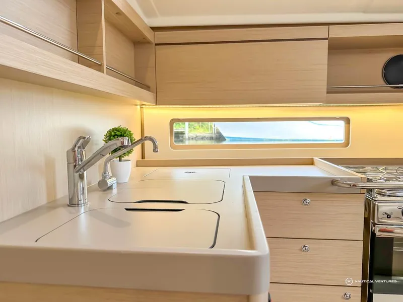 Slide: The Image of Modern kitchen area in 2024 Beneteau Oceanis 40.1 yacht with sleek cabinetry and window. - 8